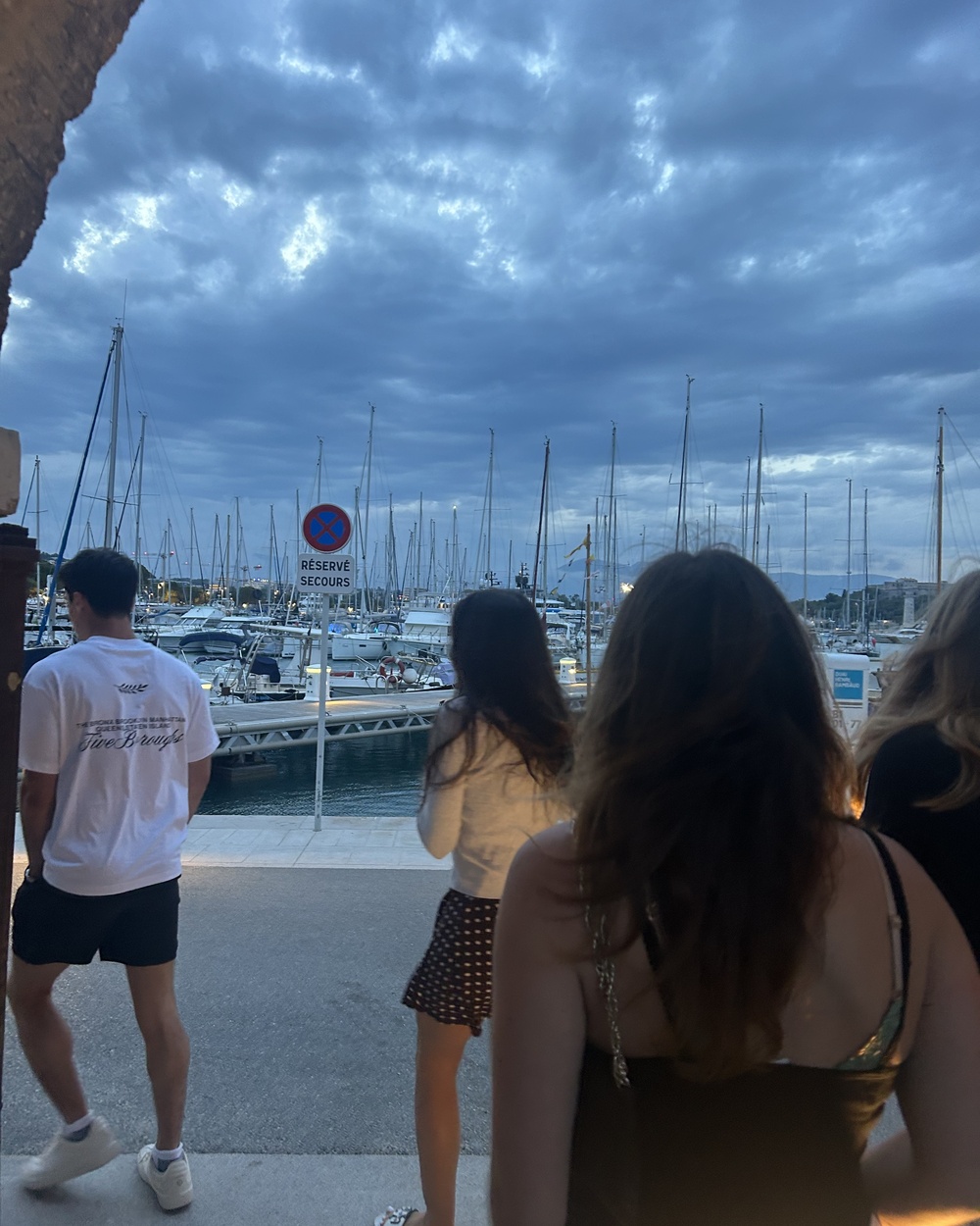 Students overlooking the Antibes marina at dusk