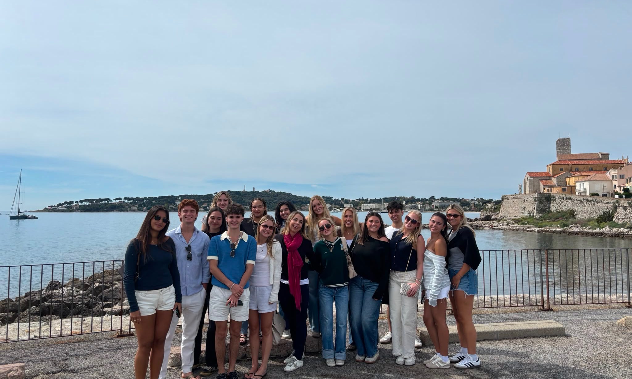 Canes in Antibes students on the Antibes waterfront, with the old town ramparts in the background